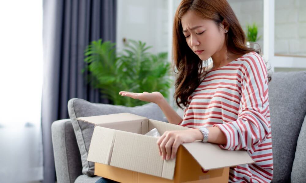 Woman opening up box to see the product is damaged