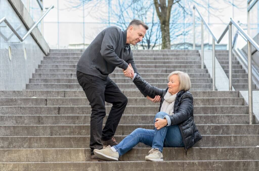 man helping a woman up from the stairs