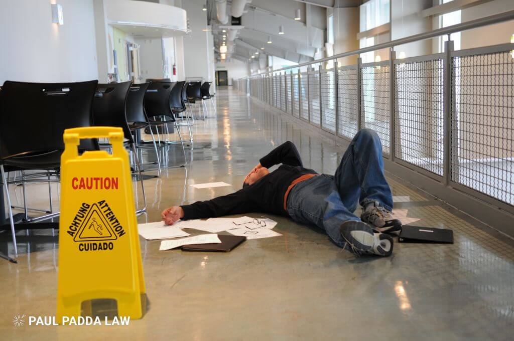 man on the wet floor next to caution sign